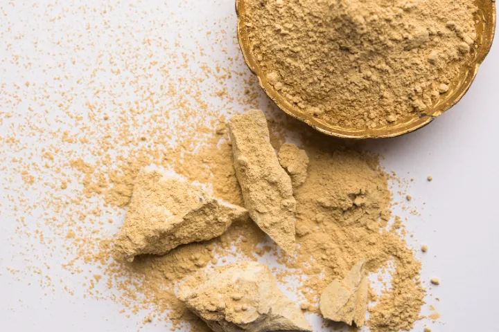 Lumps of fuller's earth beside a bowl of the milled powder